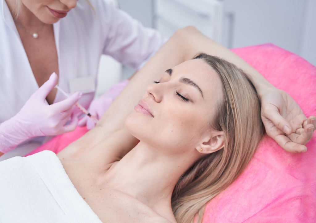 Frau wird bei den Achseln mit Botox gespritzt