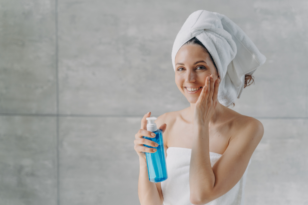Frau pflegt ihr Gesicht mit einem Toner.