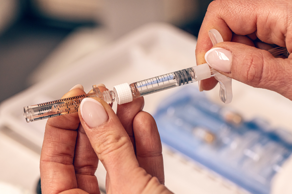 Frau füllt Hyaluron-Pen mit Flüssigkeit
