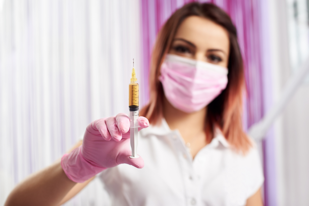 Frau hält Botox-Spritze in der Hand.